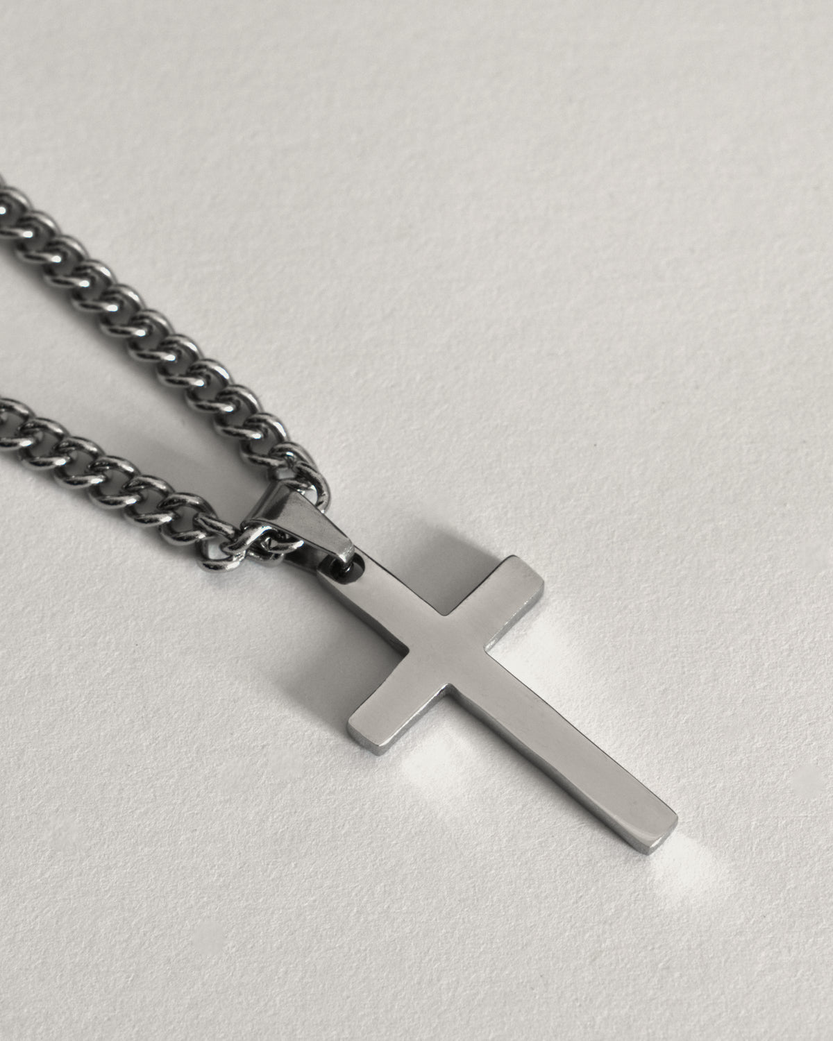 Stainless steel cross necklace on a curb chain